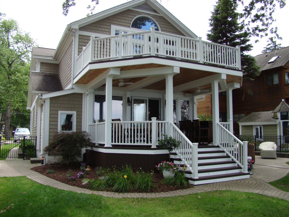 Charming two-story home with a custom porch and white railings.